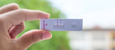 Rapid Antijen Test kiti tutan adam COVID-19 testi sırasında negatif sonuç verdi. Coronavirus Öz-Burun ya da Ev Testi, Kilitleme ve İzolasyon Konsepti