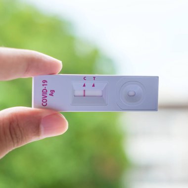Rapid Antijen Test kiti tutan adam COVID-19 testi sırasında negatif sonuç verdi. Coronavirus Öz-Burun ya da Ev Testi, Kilitleme ve İzolasyon Konsepti