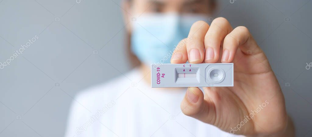 woman holding Rapid Antigen Test kit with Negative result during swab COVID-19 testing. Coronavirus Self nasal or Home test, Lockdown and Home Isolation concept