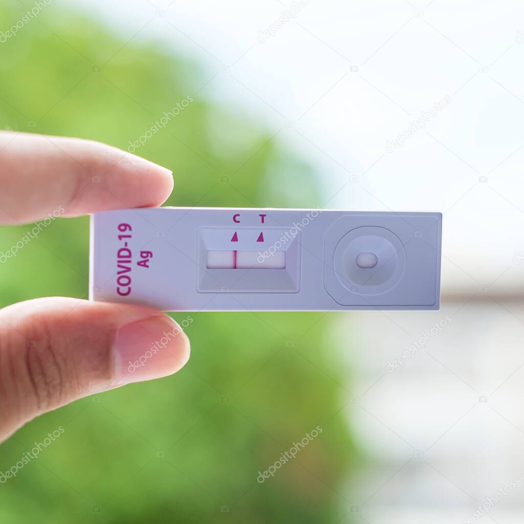 man holding Rapid Antigen Test kit with Negative result during swab COVID-19 testing. Coronavirus Self nasal or Home test, Lockdown and Home Isolation concept