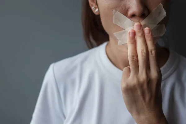 Woman show three finger with mouth sealed in adhesive tape. Freedom of speech, Human rights, Protest dictatorship, democracy, liberty, equality and fraternity concepts