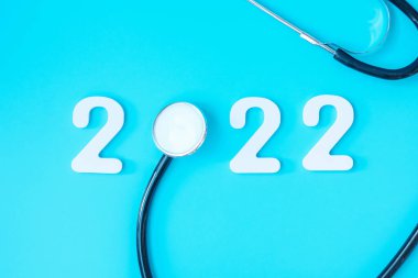 2022 Sağlık, Sigorta, Sağlık ve Tıbbi Konsept İçin Mutlu Yıllar. Mavi arkaplanda stetoskop ve beyaz numara