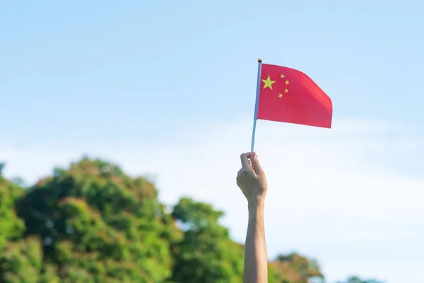 青い空の背景に中国国旗を掲げて手をつなぐ 中華人民共和国のナショナルデー 国民の祝日と幸せなお祝いの概念 — ストック写真