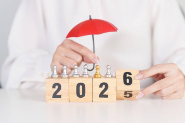 Yeni yılın kutlu olsun, elinde kırmızı şemsiyeyle satranç oynayan insanlar. hayat sigortası, sağlık sigortası, liderlik, koruma, güvenlik ve yeni yıl tatili kavramları