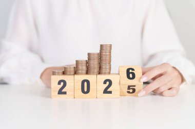 2025 'in sonundaki mutlu yeni yıl 2026' ya madeni paralarla. Para, Bütçe, vergi, yatırım, finans, tasarruf ve Yeni Yıl Çözüm kavramları