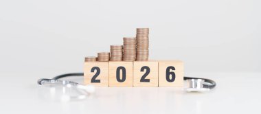Doktor Stetoskop, madeni paralar ve kırmızı kalple 2026 yılınız kutlu olsun. Sağlık, Para Kurtarma, Hedef, Çözüm, Sağlık Sigortası, Sağlık ve Sağlık Konsepti