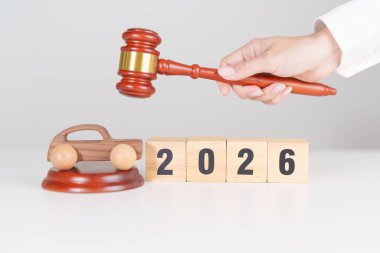 Yeni yılınız kutlu olsun. Küçük oyuncak araba modelleri ve yargıç tokmağı mahkeme masasında. Araba Kanunu, Sigorta, Otomatik Vergi, Açık Artırma ve Açık Artırma Kavramları