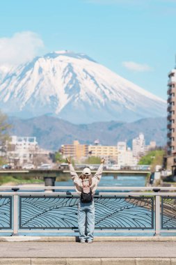 Iwate Dağı 'nı gezen kadın ve baharda çiçekli Kitakami nehri, Morioka şehrinde seyahat eden mutlu gezgin, Iwate Bölgesi, Japonya. Ünlü Landmark Seyahat ve Tatil Yeri