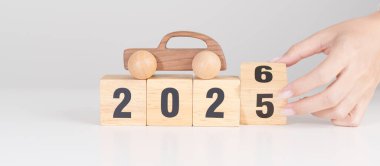 2025 'in sonundaki mutlu yıllar 2026' ya masada araba modeliyle. Otomobil Vergisi, Araba Sigortası, Finans, Araç Tamir ve Bakım ve Yeni Yıl Konsepti