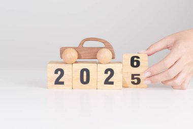 2025 'in sonundaki mutlu yıllar 2026' ya masada araba modeliyle. Otomobil Vergisi, Araba Sigortası, Finans, Araç Tamir ve Bakım ve Yeni Yıl Konsepti
