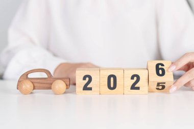 2025 'in sonundaki mutlu yıllar 2026' ya masada araba modeliyle. Otomobil Vergisi, Araba Sigortası, Finans, Araç Tamir ve Bakım ve Yeni Yıl Konsepti