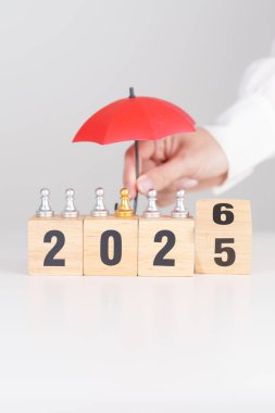 Yeni yılın kutlu olsun, elinde kırmızı şemsiyeyle satranç oynayan insanlar. hayat sigortası, sağlık sigortası, liderlik, koruma, güvenlik ve yeni yıl tatili kavramları