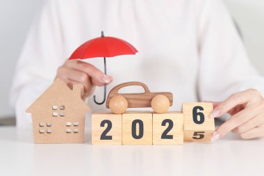 Kırmızı şemsiyeli mutlu yıllar 2026. Sigorta, gayrimenkul, ev, araba, kredi, vergi, yatırım, mortgage, finans, tasarruflar, koruma ve güvenlik 