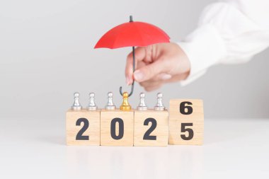 Yeni yılın kutlu olsun, elinde kırmızı şemsiyeyle satranç oynayan insanlar. hayat sigortası, sağlık sigortası, liderlik, koruma, güvenlik ve yeni yıl tatili kavramları