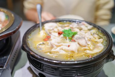 Sichuan Balığı yiyen turist kadın turist ve turşu yeşili ya da restoranda Suan Cai Yu. Chengdu, Chongqing ve Çin 'de turistler için popüler yiyecekler. Çin Asya ve Sichuan Gıda Konsepti