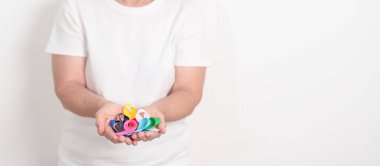 Dünya Kanser Günü, 4 Şubat. Renkli kurdeleli yaşlılar, mavi, sarı, kırmızı, yeşil, beyaz, pembe ve gri, yaşayan ve hastalıklı insanları desteklemek için. Sağlık, Sağlık, Farkındalık ve Sigorta kavramı