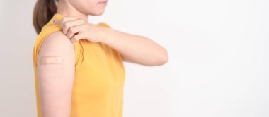 Aşı olduktan sonra bandajlı yetişkin kadın. Grip aşısı, HPV, Zoster, IPD, DTP veya Difteri, Tetanos ve Pertusis, MMR, Hepatit B, Covid ve Varicella aşısı