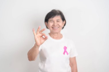 Pembe Ekim Göğüs Kanseri Bilinci ayı için kurdelesi olan yaşlı bir kadın, Mayıs Kadın Sağlığı, Şubat Dünya Kanser Günü, insanlara yaşam ve hastalık desteği veriyor. Ulusal kanser kurtulanları ayı