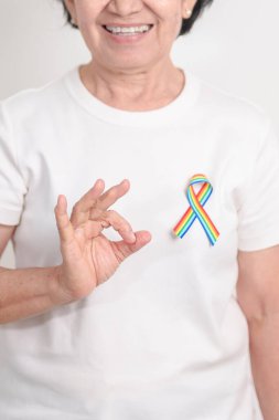 Haziran Gurur Ayı, Nisan Otizm Bilinci, Kanser Farkındalığı, Şubat Dünya Kanser Günü, Ekim Dünya Bakımevi ve Palyatif Bakım Günü konsepti için LGBTQ Gökkuşağı kurdelesine sahip yaşlılar