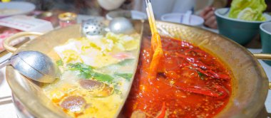 Geleneksel güveç ya da baharatlı çorba yiyen bir kadın turist. Chengdu, Chongqing ve Çin 'de turistler için popüler yiyecekler. Çin Asya ve Sichuan Gıda Konsepti