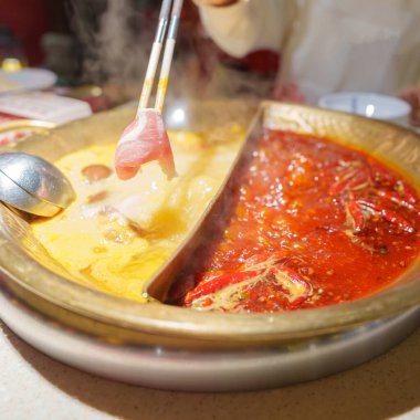 Geleneksel güveç ya da baharatlı çorba yiyen bir kadın turist. Chengdu, Chongqing ve Çin 'de turistler için popüler yiyecekler. Çin Asya ve Sichuan Gıda Konsepti