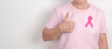 Pembe Ekim Göğüs Kanseri Bilinci ayı için kurdelesi olan yaşlı bir kadın, Mayıs Kadın Sağlığı, Şubat Dünya Kanser Günü, insanlara yaşam ve hastalık desteği veriyor. Ulusal kanser kurtulanları ayı