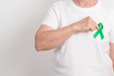 Mart ayındaki bipolar bozukluk konsepti için yeşil kurdeleli yaşlılar, beyin felci farkındalığı ayı, böbrek kanseri ve travmatik beyin hasarı, TBI. Sağlık ve Dünya Kanser Günü