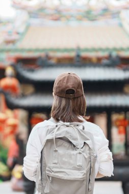 Woman traveling in Wat Mangkorn Kammalawas, Leng Nuei Yee as Chinese temple. Asian traveler visiting at Yaowarat road or Chinatown of Bangkok, landmark and popular for tourist attractions in Thailand