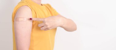 Aşı olduktan sonra bandajlı yetişkin kadın. Grip aşısı, HPV, Zoster, IPD, DTP veya Difteri, Tetanos ve Pertusis, MMR, Hepatit B, Covid ve Nipha virüsü aşısı