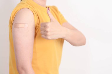 Aşı olduktan sonra bandajlı yetişkin kadın. Grip aşısı, HPV, Zoster, IPD, DTP veya Difteri, Tetanos ve Pertusis, MMR, Hepatit B, Covid ve Nipha virüsü aşısı