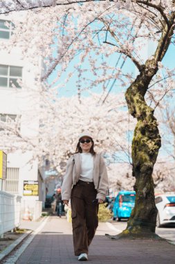Baharda Sakura Kiraz Çiçeği ile Goryokaku Kulesi Parkı 'nı gezen kadın Hakodate City, Hokkaido, Japonya' da mutlu bir gezgin. Meşhur Landmark, Japonya Seyahat ve Tatil Yeri