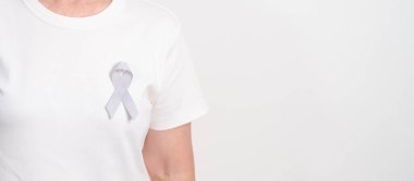 Mayıs Kanser Farkındalığı ayı için gri kurdeleli yaşlılar ve Astım Bilinci, Yaşam İnsanları Destekleme Kurdelesi. Sağlık ve Şubat Dünya Kanser Günü