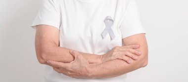 Mayıs Kanser Farkındalığı ayı için gri kurdeleli yaşlılar ve Astım Bilinci, Yaşam İnsanları Destekleme Kurdelesi. Sağlık ve Şubat Dünya Kanser Günü