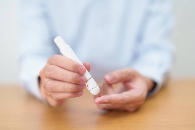 Kan damlası glikoz testi ya da dijital kan şekeri ölçeriyle kontrol edilen diyabet ile parmak üstüne tükenmez kalem kullanan bir el. Kan şekeri, Diyabet Günü, Glisemi, Hipoglisemi, Hiperglisemi ve İnsülin