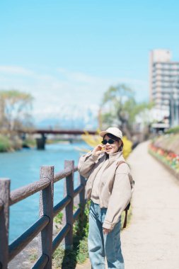 Iwate Dağı 'nı gezen kadın ve baharda çiçekli Kitakami nehri, Morioka şehrinde seyahat eden mutlu gezgin, Iwate Bölgesi, Japonya. Ünlü Landmark Seyahat ve Tatil Yeri