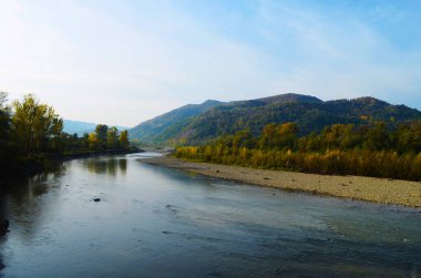 Dağları, ormanı ve önünde bir nehri olan bir manzara. Güzel manzara.