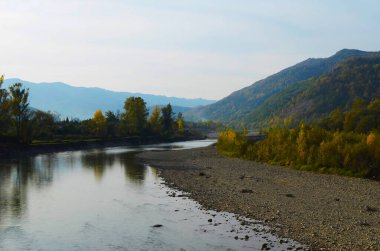 Dağları, ormanı ve önünde bir nehri olan bir manzara. Güzel manzara.
