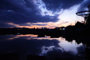 Günbatımı göl iskelesi manzarası. Gün batımında göl iskelesinde. Mavi gökyüzü ile günbatımı gölü