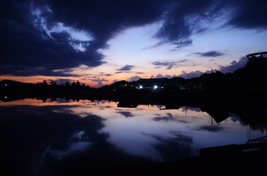 Günbatımı göl iskelesi manzarası. Gün batımında göl iskelesinde. Mavi gökyüzü ile günbatımı gölü