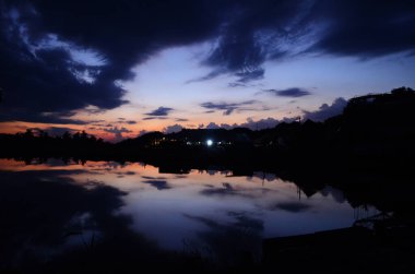 Günbatımı göl iskelesi manzarası. Gün batımında göl iskelesinde. Mavi gökyüzü ile günbatımı gölü