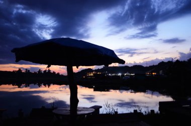 Günbatımı göl iskelesi manzarası. Gün batımında göl iskelesinde. Mavi gökyüzü ile günbatımı gölü