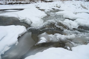 Kış zamanı dağ nehri. Ladin ormanı ve karla kaplı kıyısı olan Karpatya manzarası. Ulusal Park, Ukrayna