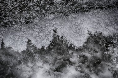 Kışın buzsuz küçük bir nehir. Nehir suyu akıntısı. Kar örtüsü. Kış soyut arkaplanı.