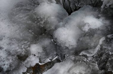 Kışın buzsuz küçük bir nehir. Nehir suyu akıntısı. Kar örtüsü. Kış soyut arkaplanı.