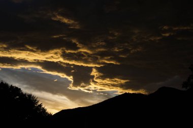 Sarı altın bulutlar gökyüzünde Akşam dağlarda