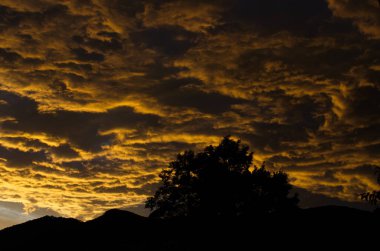 Sarı altın bulutlar gökyüzünde Akşam dağlarda