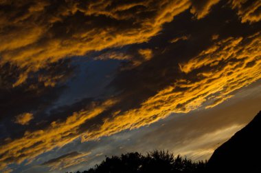 Sarı altın bulutlar gökyüzünde Akşam dağlarda