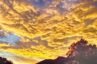 Sarı altın bulutlar gökyüzünde Akşam dağlarda