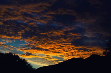 Sarı altın bulutlar gökyüzünde Akşam dağlarda