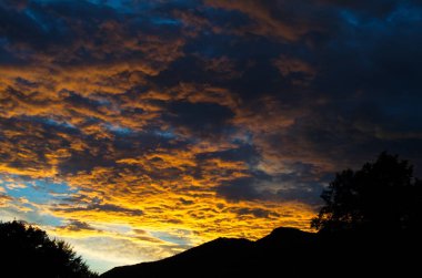 Sarı altın bulutlar gökyüzünde Akşam dağlarda